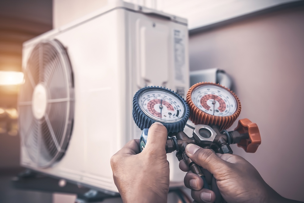 Technician using pressure gauges to check a heat pump system in Surrey, BC