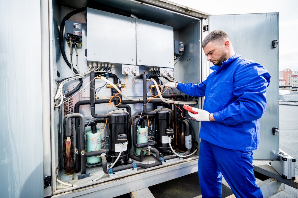 Technician performing heat pump repair in Surrey, BC for Papa Plumbing