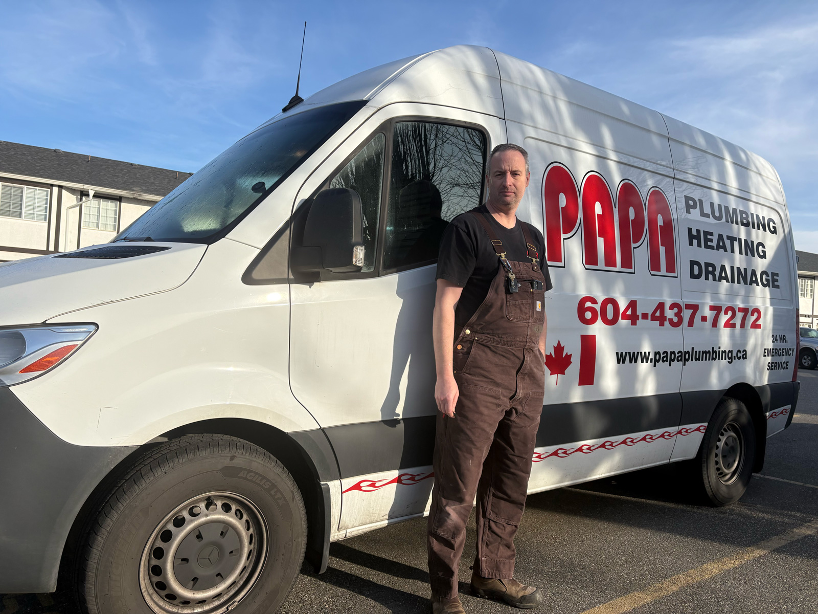 Papa Plumbing technician standing beside a branded plumbing, heating, and drainage service van in Vancouver, BC.